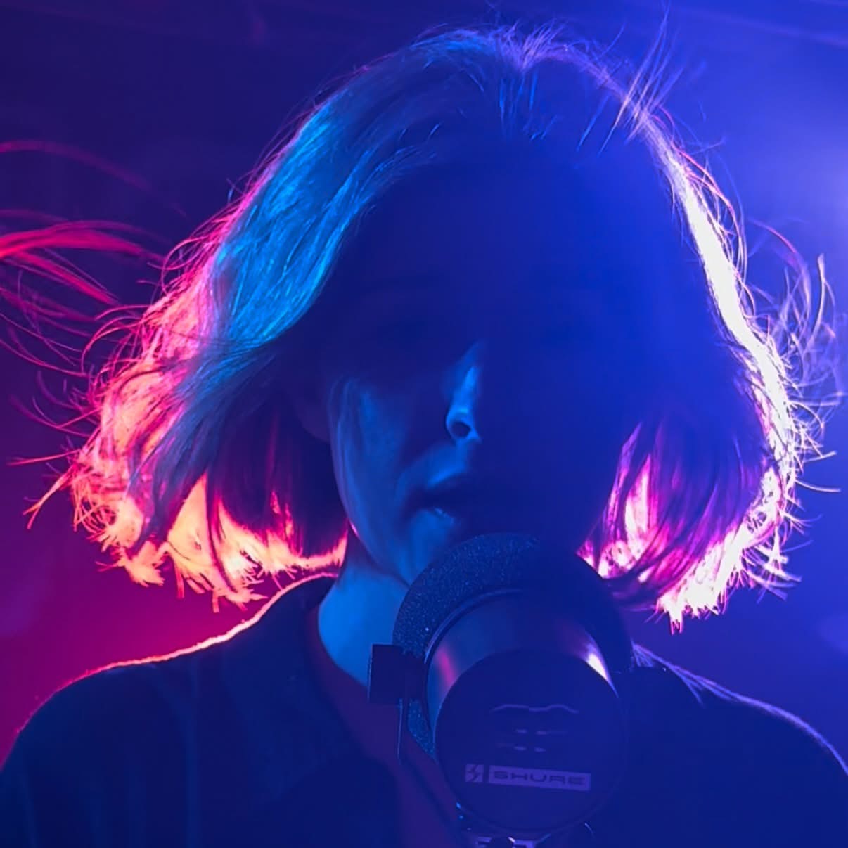 Maggie Moon under blue and purple stage lighting
